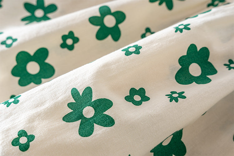Detail of the floral print on the Marktox girls' green pleated cotton dress